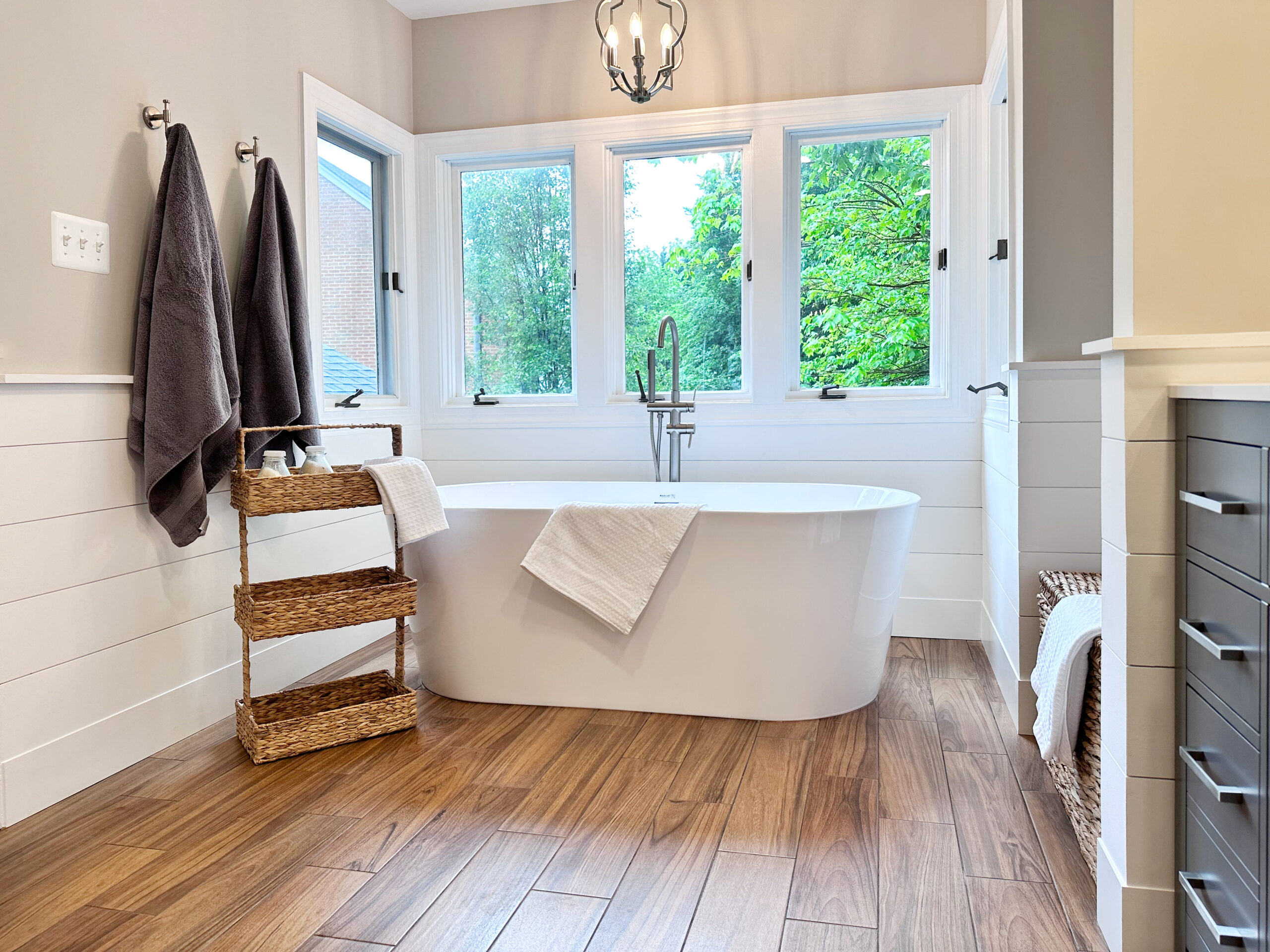 large master bathroom with white tub and wood flooring
