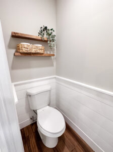 white toilet and wood floating shelves