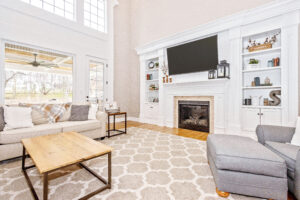 large open living room with a large fireplace and television with built-in storage