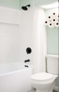 small remodeled bathroom with pale green walls and white bathtub