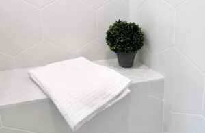 interior of a shower with a built-in bench and stone grey tiling