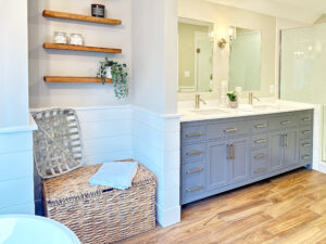 large master bathroom with grey cabinets and wood shelving